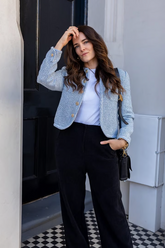 a lady in a white top, a blue jacket and a pair of black pants